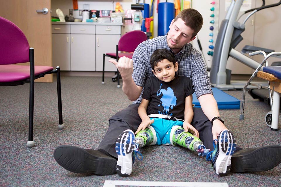patient with prosthetic legs and therapist